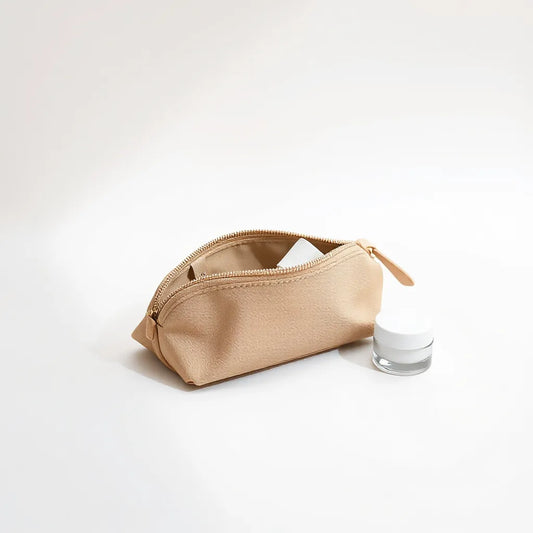 Mini moisturizer container and travel skincare pouch with compact bottles arranged neatly for on-the-go hydration