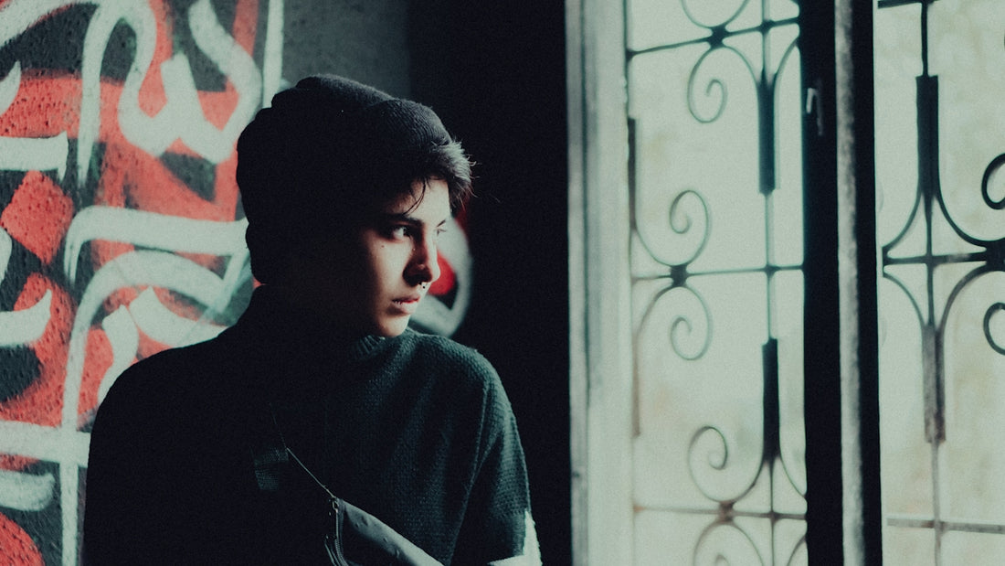 a young man standing in front of a window