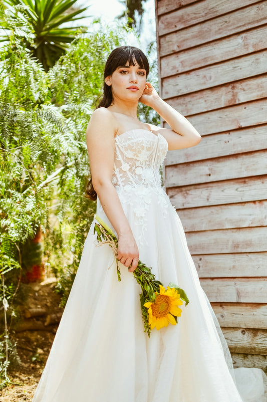 a woman in a white dress holding a bouquet of flowers